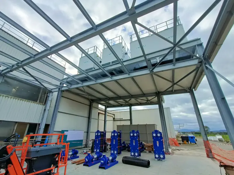 Interno di una struttura industriale con travi e passerelle metalliche